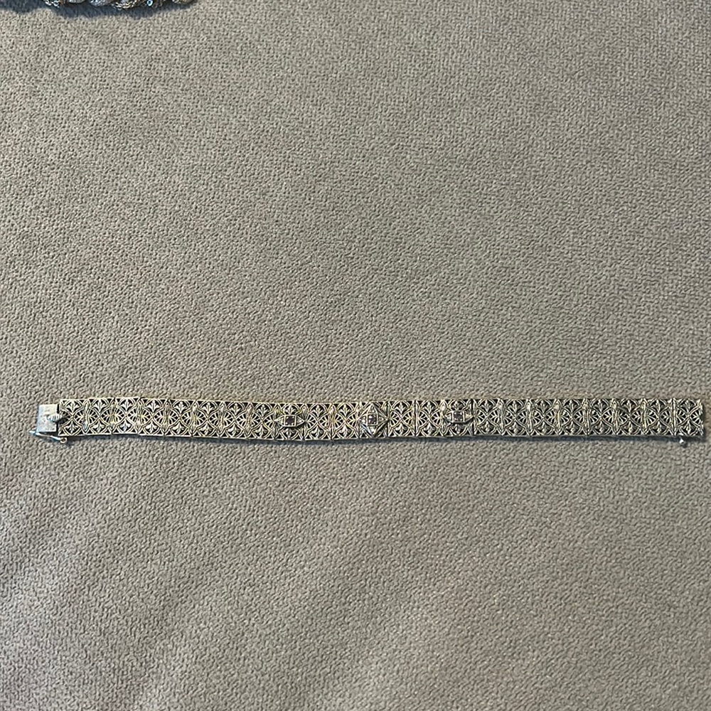 VINTAGE STERLING INTRICATE BRACELET WITH 3 AMETHYST CHIPS AND SMALL DIAMONDS.